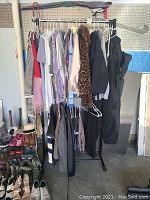 Full rack of women's clothing including jackets, blouses, sweaters, pants, and shoes beneath the rack.