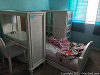 Full view of bunk bed unit converted to single, including desk with lamp, chair, and storage drawers with colorful fronts, bed has bedding with pink blanket