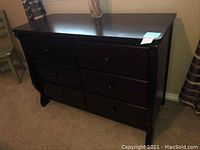 Front view of the 6 drawer dark wood dresser showing all drawers and curved sides.