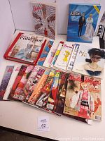 Full view of the collection showing various Barbie books and magazines arranged on table including Barbie Bazaar, Barbie Collector, clippings binder, and other titles.