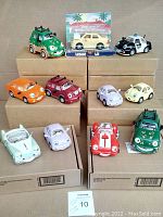 Photo showing all 11 Chevron Cars including 10 loose and 1 in box on brown boxes.
