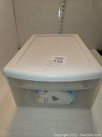 Closed Sterilite plastic drawer with white lid and frosted front panel, showing external condition of container.