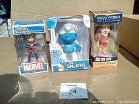 Three boxed figurines: Funko Rock Candy Captain Marvel, Vanity Smurf by Peyo, Doctor Who Clara Oswald Wacky Wobbler bobble-head