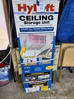 Photo of the unopened Hyloft ceiling storage unit box showing brand, model, and storage unit image.