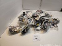 Lot of about 10 Playmobil toys, individually sealed in clear plastic bags, including sheriff and space-themed items.