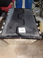 Closed plastic tote with black interlocking lid for garage accessories