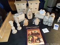Overview of unfinished wood craft lot with all items arranged on a glass table showing shelf, organizers, candlesticks, milk bottles, and book.