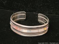 Front and side view of sterling silver cuff bracelet highlighting twisted rope edge design and polished center band.