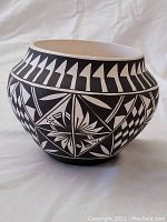 Photo of the pottery bowl showing the full side view with geometric patterns and shape.