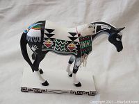 Front angle view of a Painted Pony collectible figurine showcasing detailed geometric and nature-inspired painted designs, mounted on a rectangular base with Greek key border.