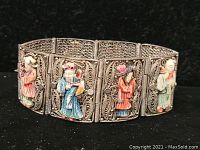 Front view of silver Asian bracelet showcasing multiple linked panels, each with a colorful hand-painted figurine in traditional clothing.