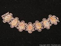 Full view of the silver Asian bracelet showing seven linked oval enamel panels and the filigree silver work.