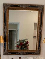 Front view of large rectangular wall mirror with ornate distressed wooden frame showing carved details and reflective glass surface.