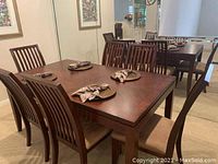 Dining table with six matching chairs against mirrored wall