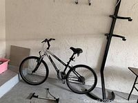 Side profile of bike leaning against wall showing full bike and frame condition