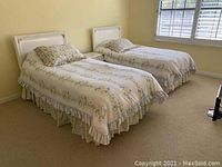 Two twin beds side by side with floral bedspreads and headboards, showing the twin bed frames.
