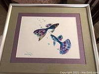 Framed watercolor painting showing two colorful fantail fish with visible bubbles and signature, focusing on overall presentation.