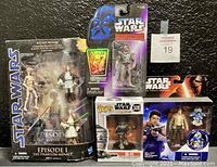 Photo showing the Star Wars collectibles lot with the Episode I: The Phantom Menace action figure set, Star Wars The Force Awakens two-figure set, Shadows of the Empire Chewbacca figure, and a Funko Pop! vinyl figure, all sealed and in original packaging.