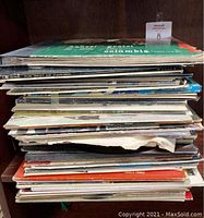 Stack of assorted vinyl records showing album edges and thickness