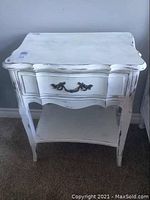 Front view of vintage white distressed Andrew Malcolm night stand with drawer and bottom shelf