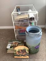 Full front view of craft supply cart with contents, painted milk can, wooden box, and decorative sign on floor.