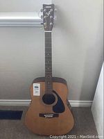 Full front view of a Yamaha F310P acoustic guitar showing natural wood finish and black pickguard.