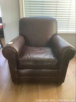 Full front view of brown leather armchair