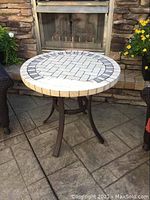 Patio table front view showing the stone top and aluminum base with three legs.