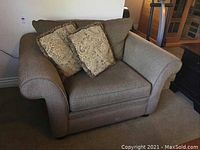 Front-right view of the oversized Stylus chair in mink color with rolled arms and 2 patterned cushions.