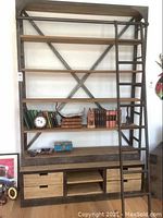 Full front view of shelving unit showing four shelves, ladder and bottom drawers.