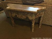 Front view showing sofa table with ornate carved apron and turned legs