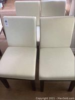 All four chairs arranged in two rows on hardwood floor