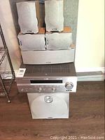 Yamaha RX-V557 receiver with Energy Encore 8 speaker system, all items stacked including receiver, five satellite speakers, center speaker, and subwoofer with bass module on floor near wall.