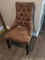 Side angle view of the fully upholstered chair showing the floral fabric pattern and dark wooden legs