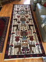 Full view of runner rug on wood floor next to sofa