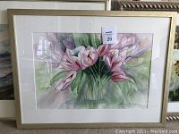 Close-up of framed watercolor floral painting of pink lilies in glass vase, signed by Susan Davis.