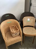 Four wicker chairs and three small wicker baskets on one chair.