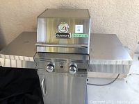 Closed lid front view showing Cuisinart logo, lid thermometer, two control knobs and side shelves