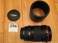 Lens body, hood and front cap arranged on hardwood floor