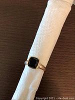 Front view of ring showing bezel-set cushion-cut onyx