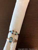 Both rings displayed on a white rolled cloth against a wood surface