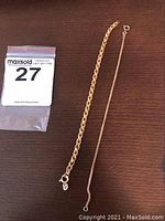 Both bracelets laid flat on wood surface with lot bag at left