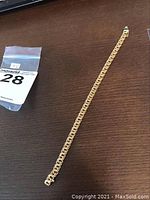 Full view of bracelet laid flat on surface with lot tag visible