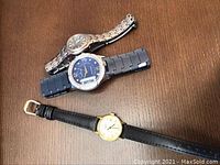 Overhead view of all three watches on wooden surface