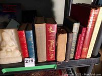 Shelf with a row of hardcover books including titles Gone with the Wind, Anna Karenina, Pride and Prejudice, Rubaiyan of Omar Khayyam, Hans Andersen Fairy Tales and more.