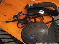 Black textured Tipperary protective riding helmet on wooden surface.