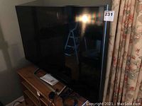 Front and side view of the 55" TV on stand with listing sticker