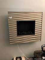 Front view of beige wavy patterned wall mounted electric fireplace with display window for flame effect