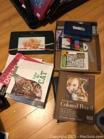 Overview of items including tins of colored pencils, sketchpads, coloring books and markers