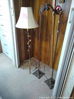 Three vintage floor lamps grouped together: one with cream shade and leaf-decorative metal stem, two metal lamps without shades with rectangular bases